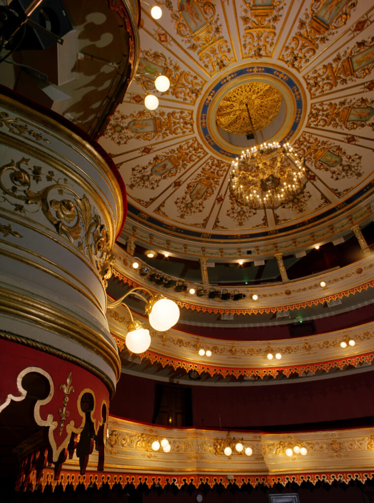 Gamla träbalkonger med detaljerad utsmyckning i guld på Stora Teatern.
