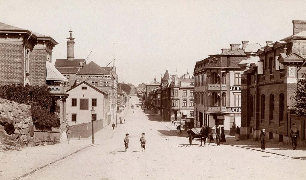 Gamla hus längs med Karl Johansgatan. Mitt i gatan står en häst och två barn springer.