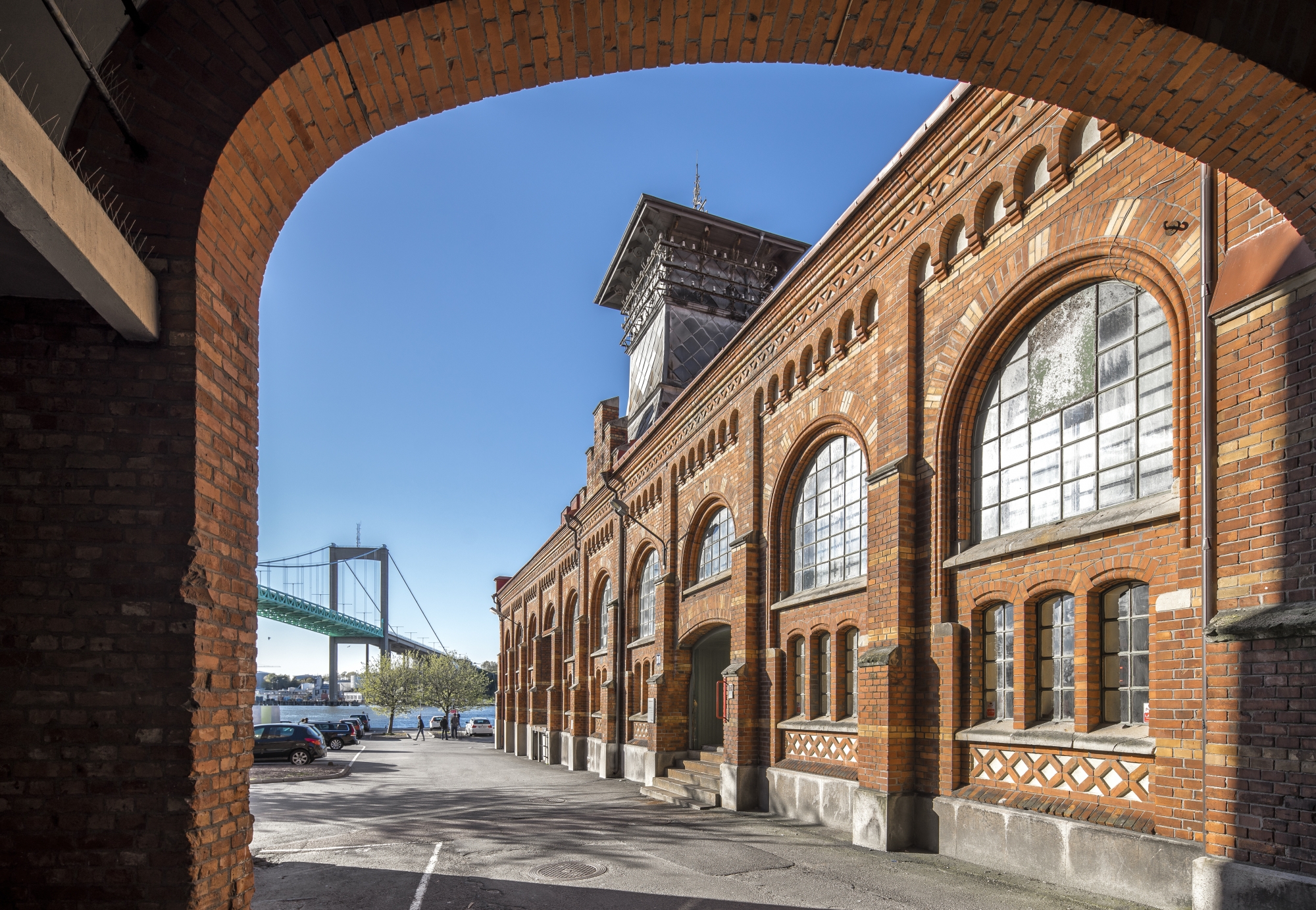 Bild tagen genom tegelvalv på en av Sockerbrukets byggnader och Älvsborgsbron