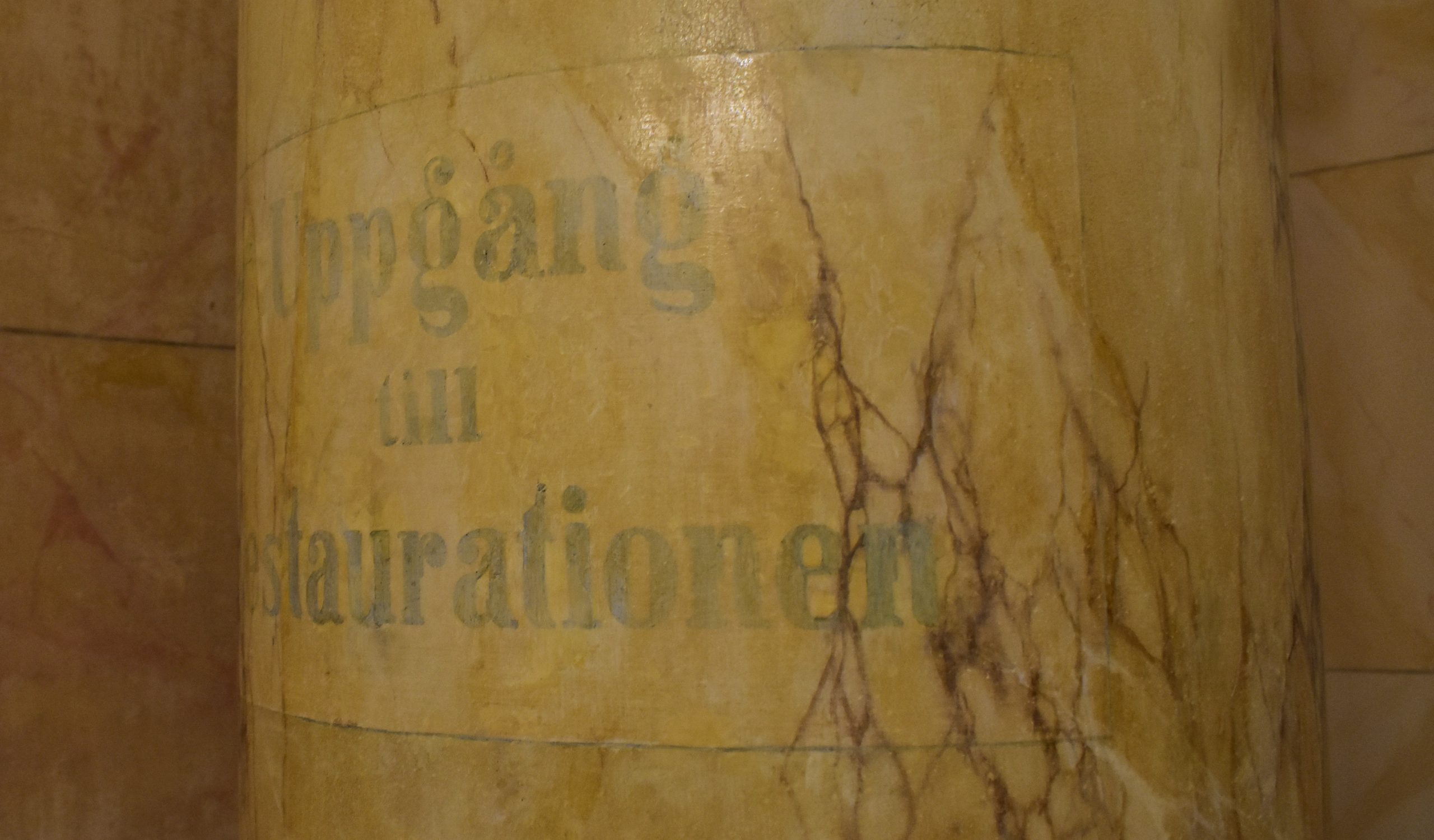 Detaljbild av kolonn på Börsen med texten Uppgång till restaurationen