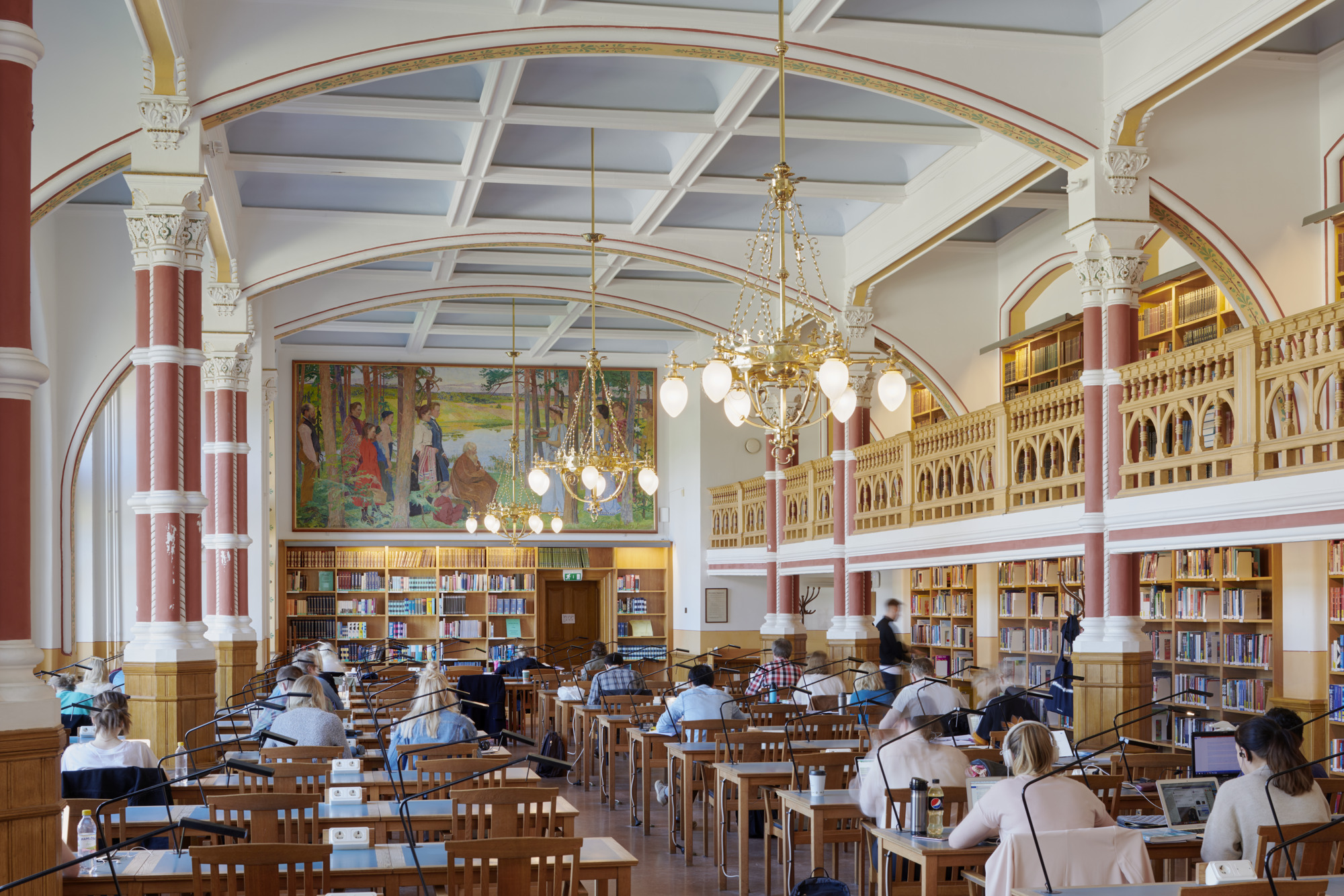 Interiör i sal med pelare, böcker och människor som läser