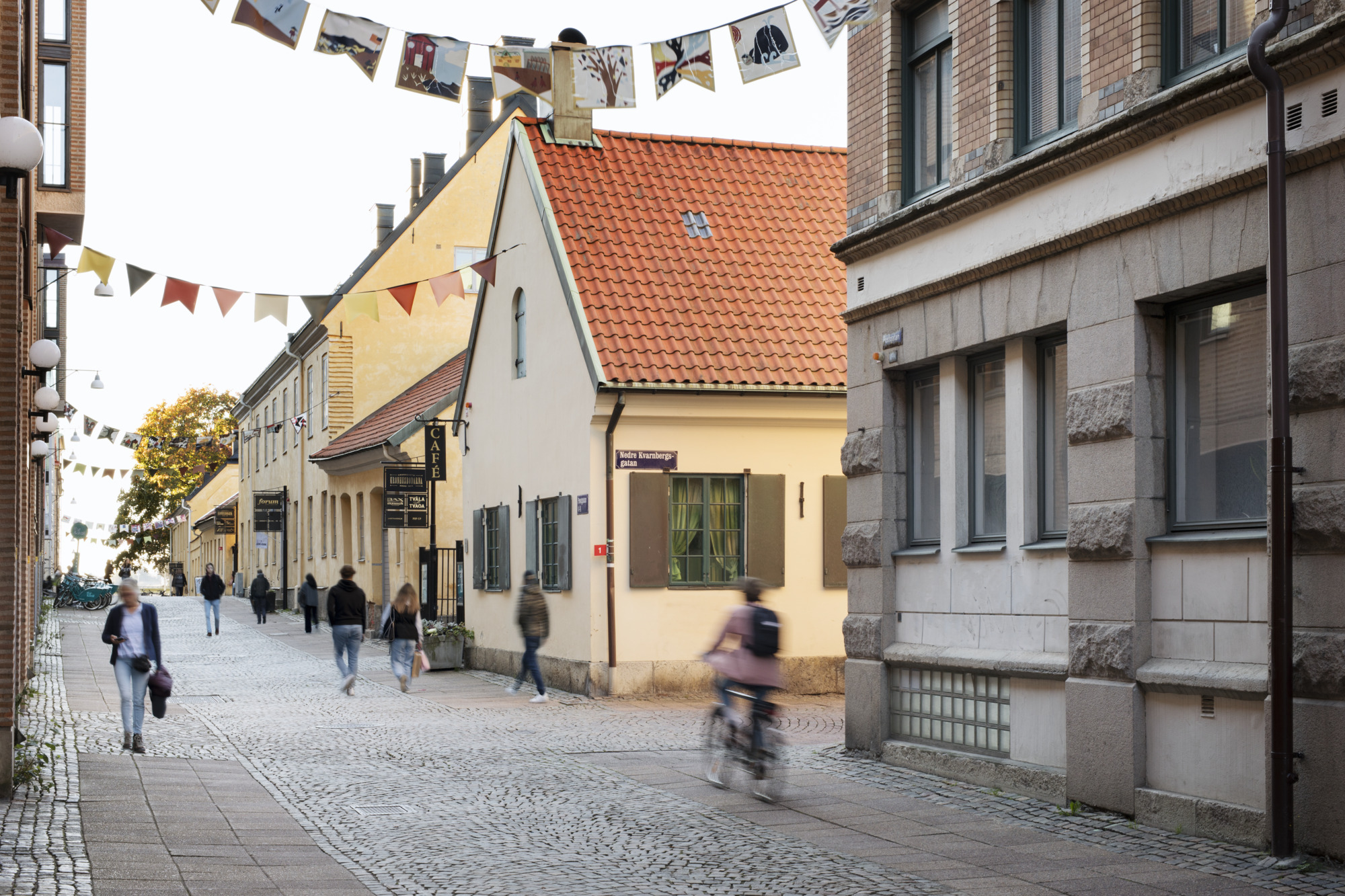 Gata med vimplar och en cyklist