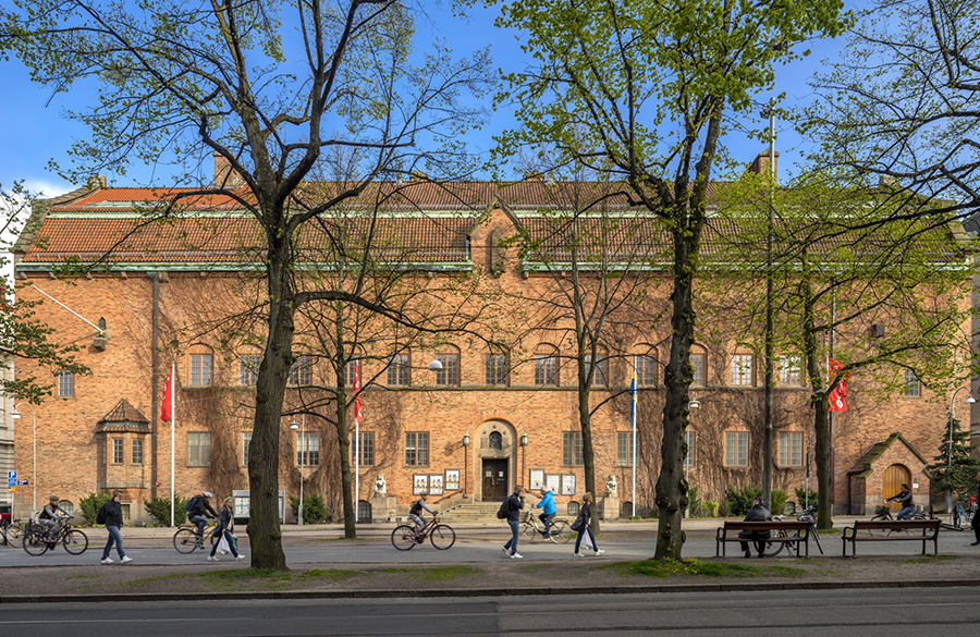 Människor i rörelse framför den röda tegelbyggnaden Röhsska museet