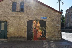 Muralmålning på en svart port till en tegelbyggnad